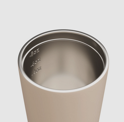 Close-up of a stainless steel tumbler with measurement markings on a plain background.