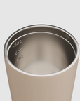 Close-up of a stainless steel tumbler with measurement markings on a plain background.