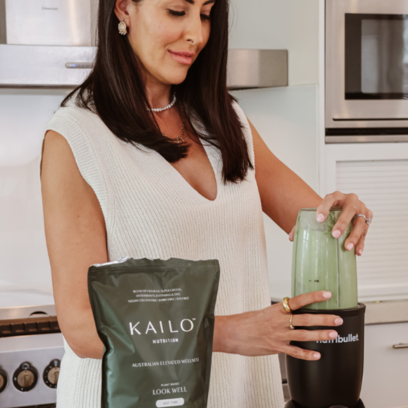 A lady in a kitchen preparing a smoothie with Look Well